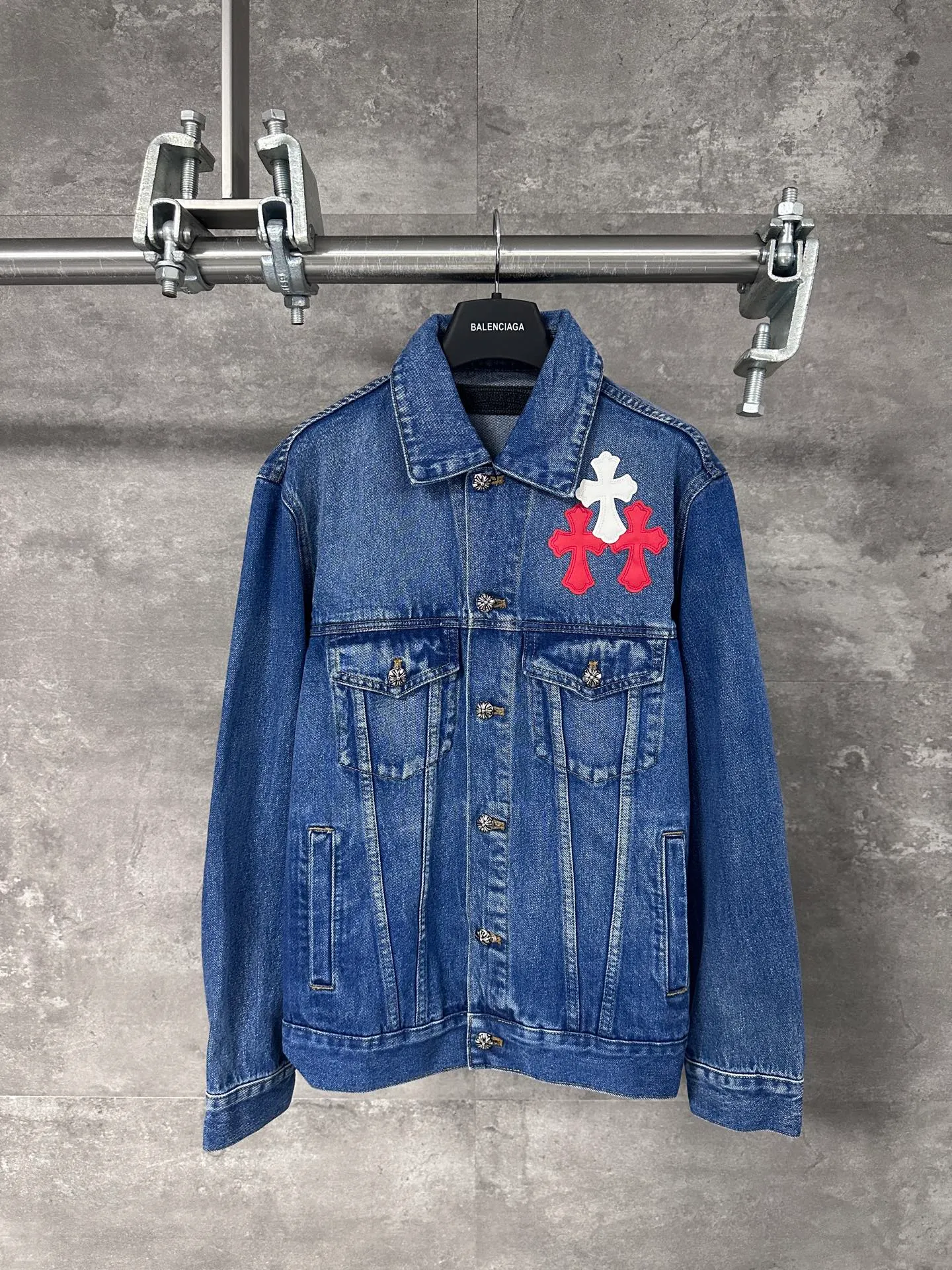 P720 CHrome Hearte cross patchwork leather denim jacket size: S M L Design details: the visual fantasy of Gothic symbols, the multi-dimensional expression of the cross totem: the red and white contrasting cross patches are staggered on the chest and back, making the brand more recognizable; the hollow cross pattern leather splicing on the sleeves combines the mystery of religious symbols with the punk-style deconstructed design. Every detail tells the dark aesthetics of Crowe's heart. Retro distressing with denim texture: Selected denim fabrics are treated with distressing techniques to show natural fading and texture, which not only retains the retro accent of denim items, but also adds a casual sense to the overall look. The ingenuity of hardware and tailoring: The metal buttons and hardware all have Croxin's iconic pattern, which shines exquisitely under the refraction of light; the neat tailoring of the classic denim jacket is suitable for a variety of wearing scenarios, and can create a strong personal style whether it is layered or worn alone. Croxin's denim jacket is not only a piece of clothing, but also a style badge that highlights unique aesthetics and rebellious attitude. For those who pursue individuality, they can leave their own hardcore mark in the fashion field.